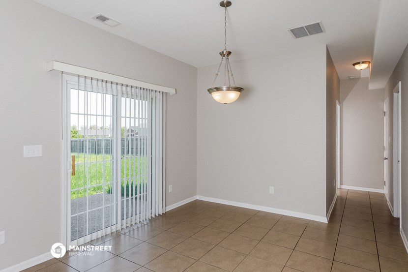 a dining room with a sliding glass door and a ceiling light