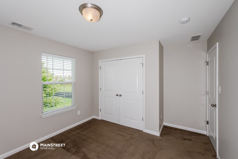 the living room of a house with a door and a window