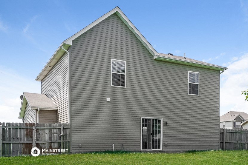 a house with gray siding and a wooden fence