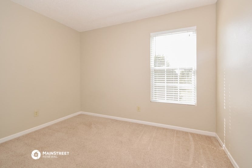 an empty room with a window and a carpet