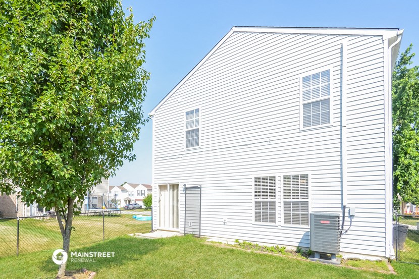 a white house with a yard and a tree