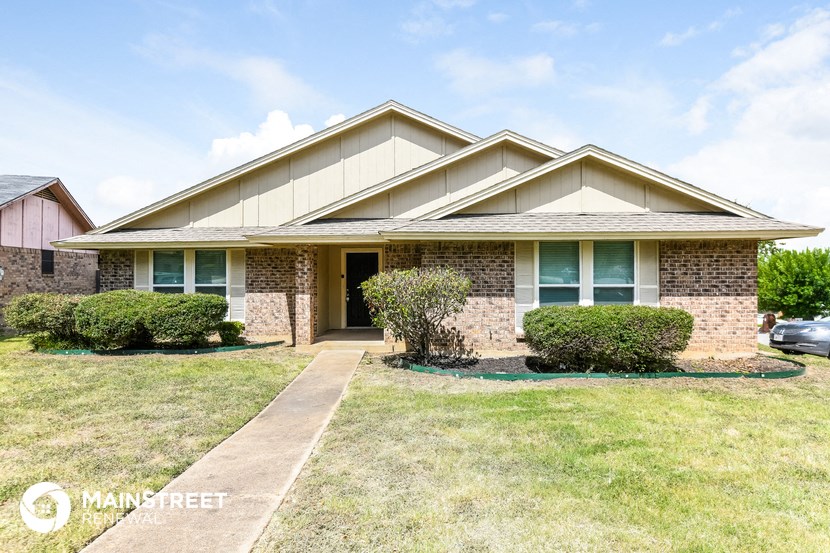 a small brick house with a lawn in front of it