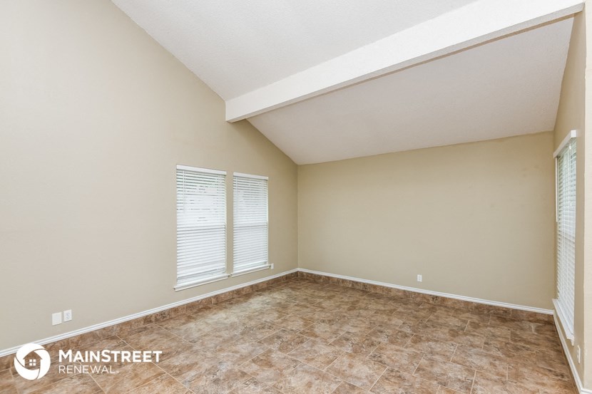 the spacious living room of this manufactured home has tile floors and beige walls