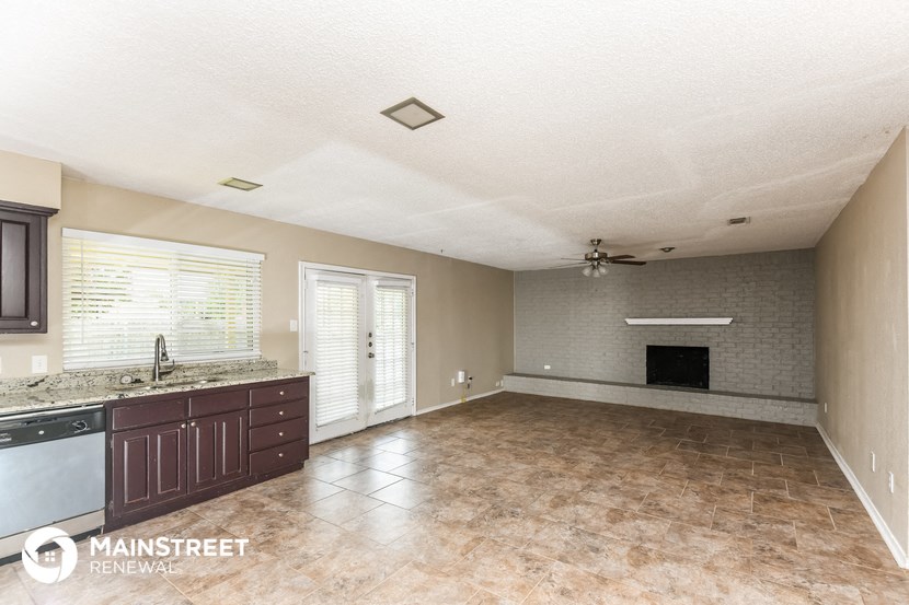 an empty kitchen and living room with a fireplace