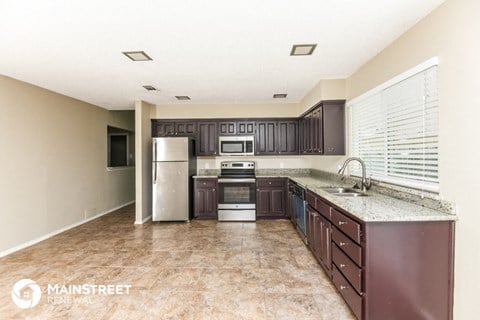 a kitchen with brown cabinets and stainless steel appliances