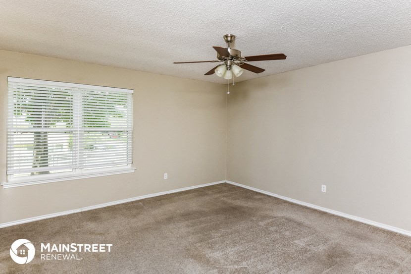 a bedroom with a ceiling fan and a window