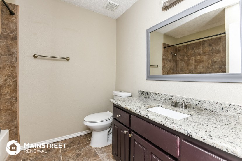 a bathroom with a toilet and a sink and a mirror