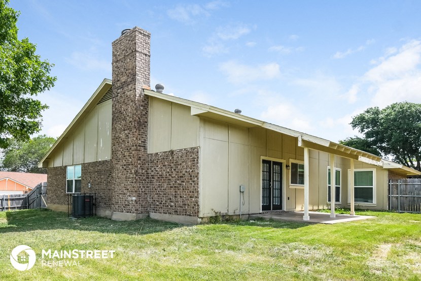 the front of a house with a brick wall and a porch