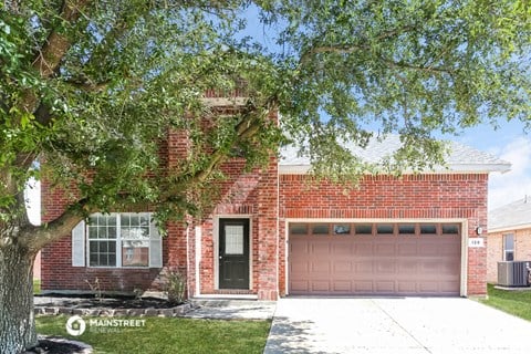 a house with a pink garage door and a tree