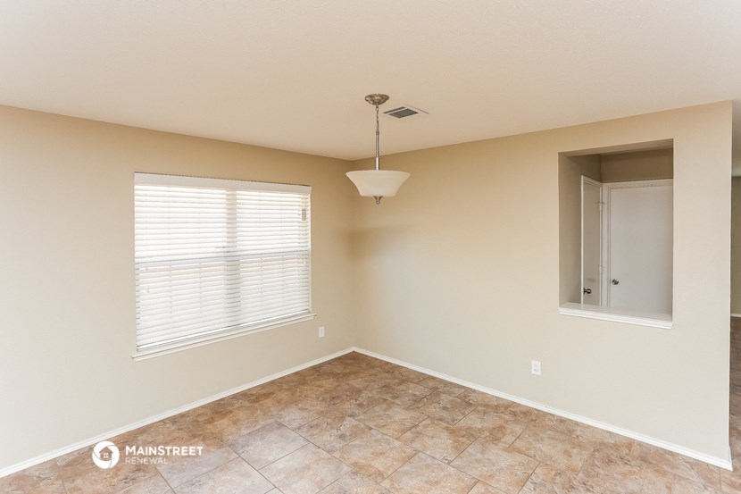 the spacious living room with a window and a door to the bathroom