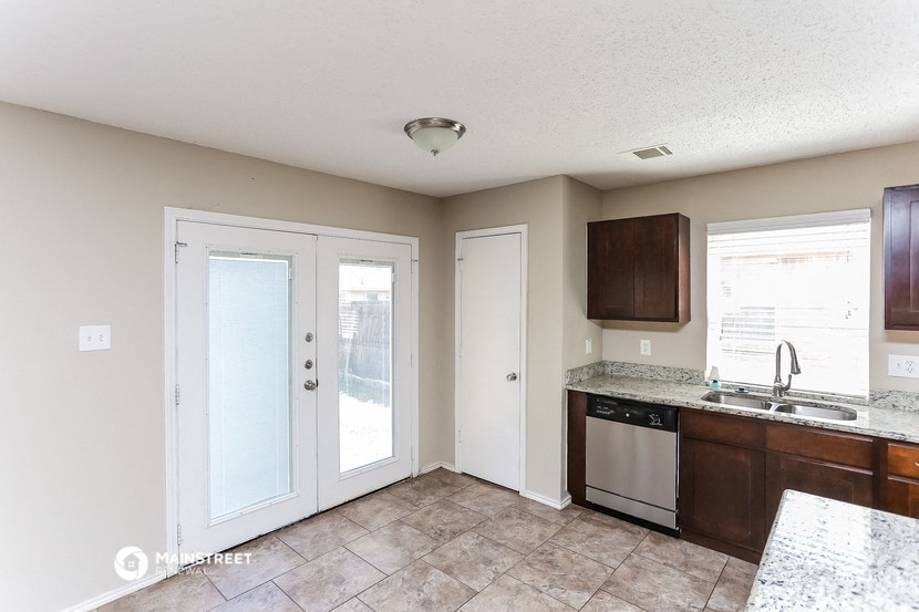a kitchen with two doors and a sink and a counter top