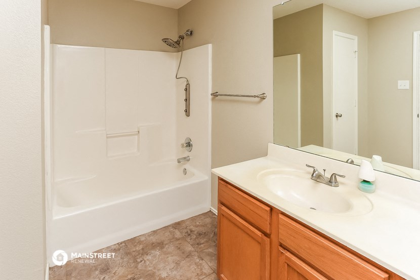 a bathroom with a shower and a sink and a mirror