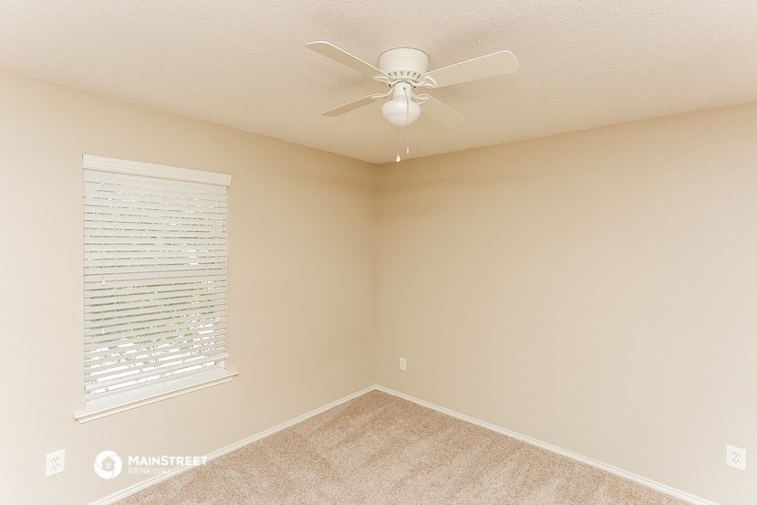 a bedroom with a ceiling fan and a window