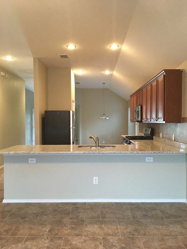 an empty kitchen with wooden cabinets and a counter top