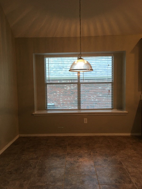 an empty room with a window and a lamp