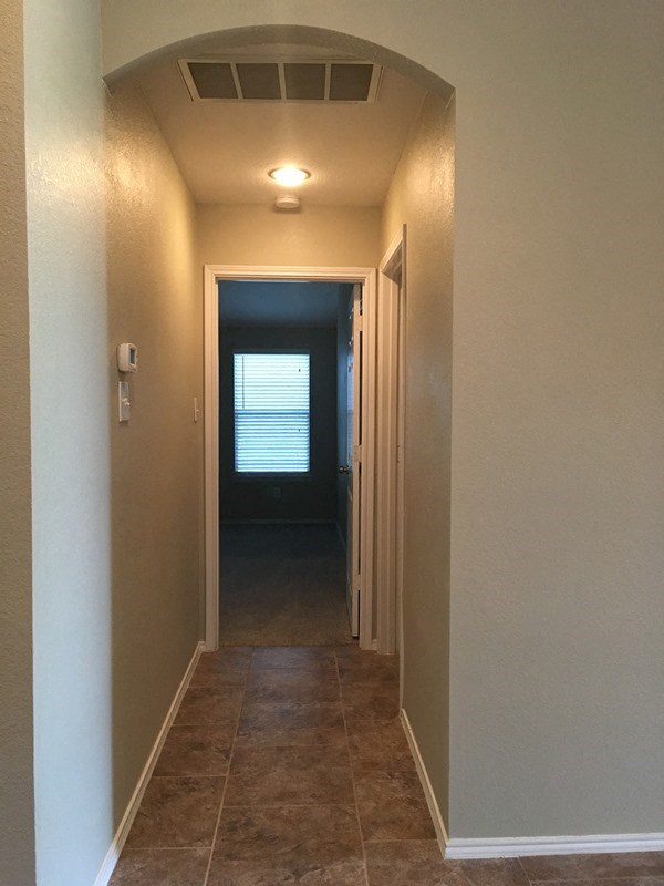 a hallway with a door to a room and a window