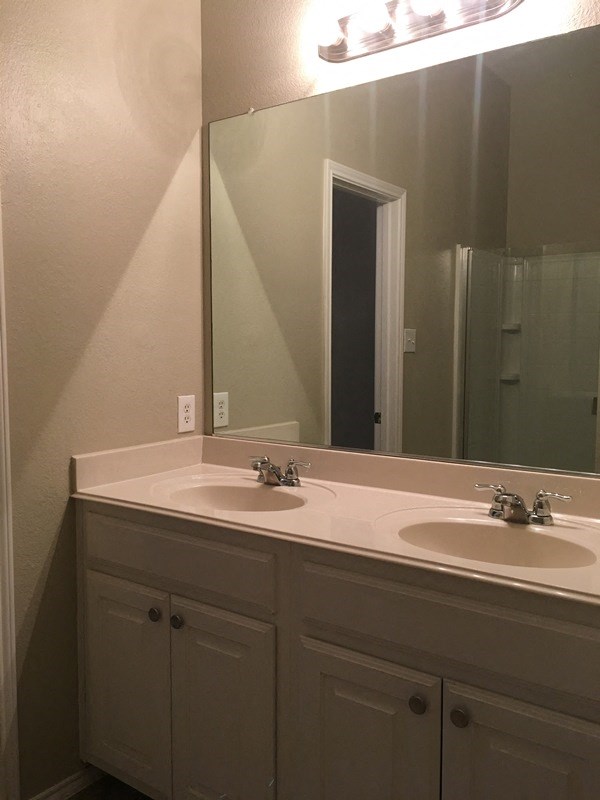 a bathroom with two sinks and a large mirror