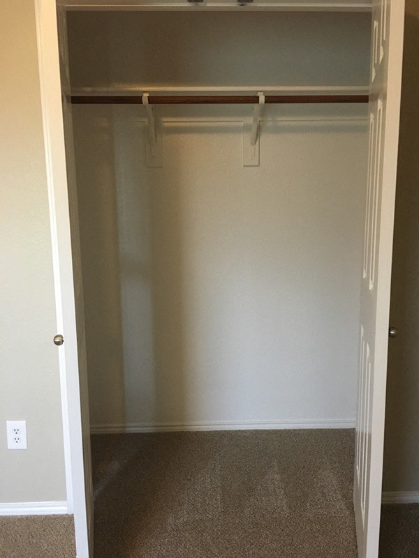 an empty closet in a room with a door open