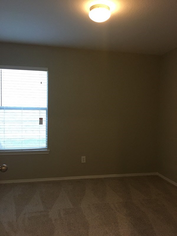 an empty room with a window and a light on the ceiling