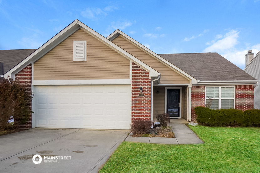 a house with a white garage door and a lawn