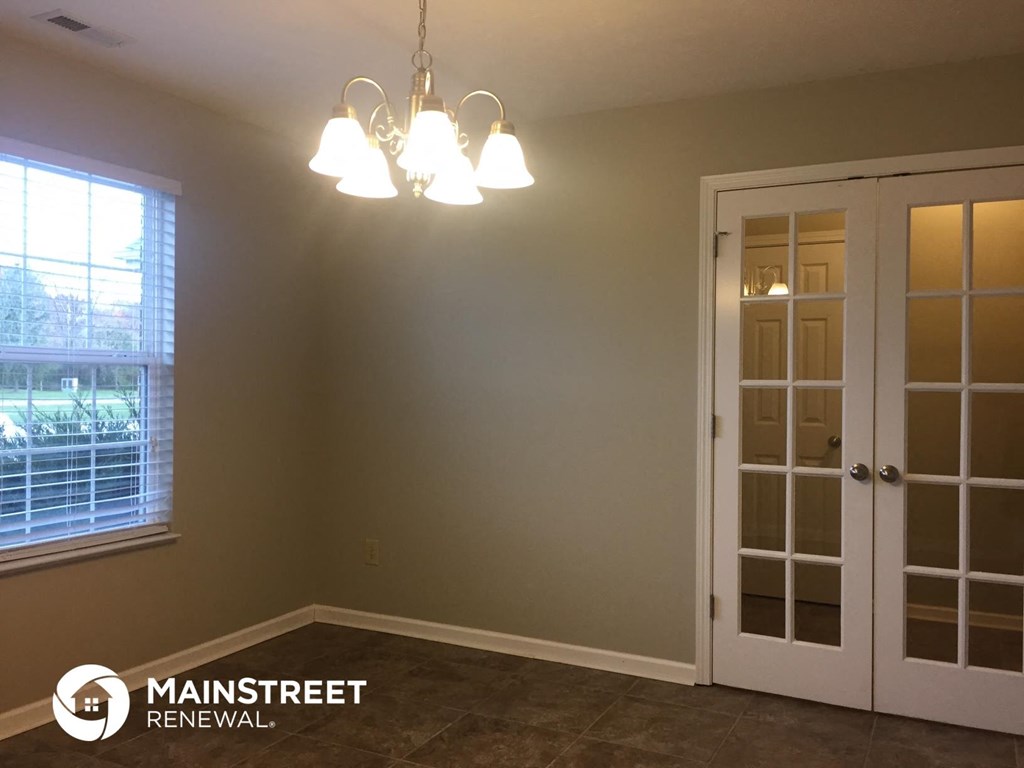 a dining room with two glass doors and a chandelier