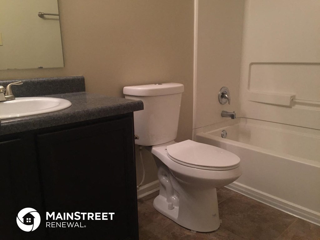 a bathroom with a toilet and a sink and a bath tub