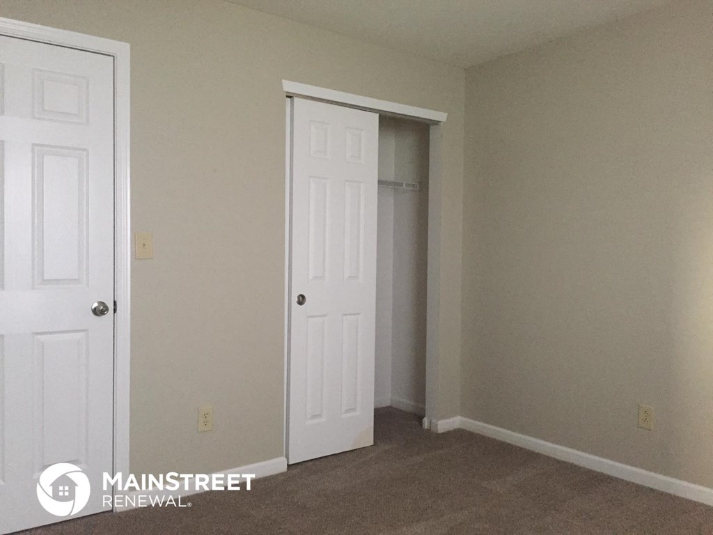a room with a closet and a white door     and a door