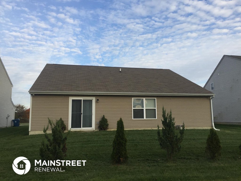 a home with a brown roof on a grass covered yard
