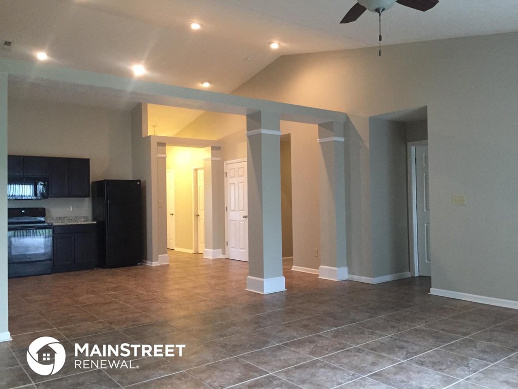 a large living room with a tile floor and a ceiling fan