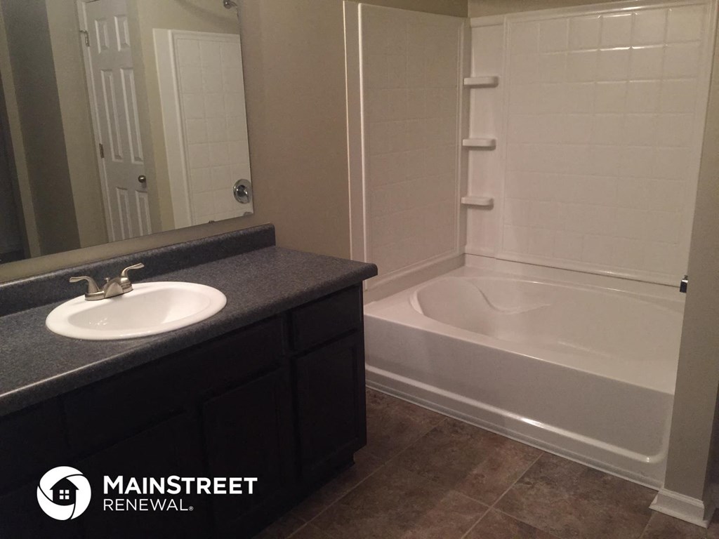 a bathroom with a sink and a tub and a mirror