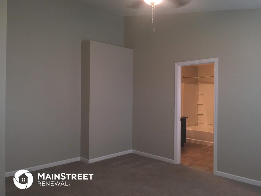 an empty room with a hallway and a door to a closet