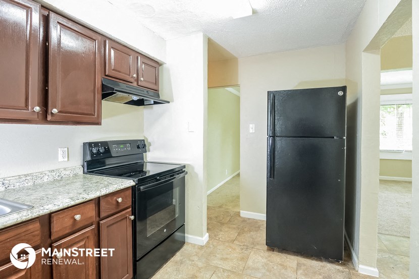 a kitchen with black appliances and wooden cabinets and a black refrigerator