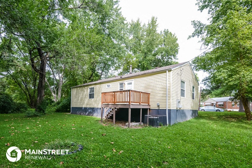 a house with a deck and a yard with trees