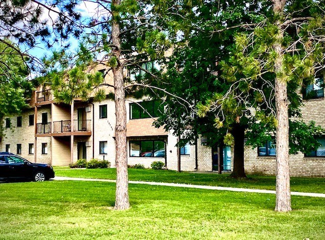 a large apartment building with trees in front of it