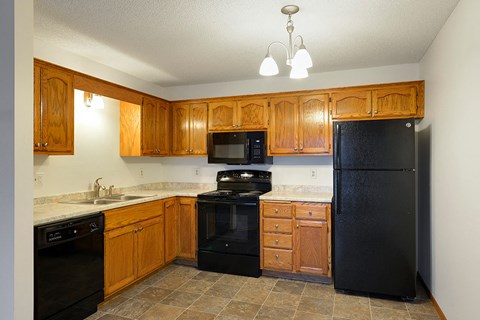 a kitchen with black appliances and wooden cabinets