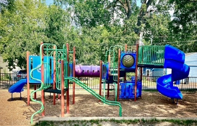 a playground with a blue slide and other playground equipment