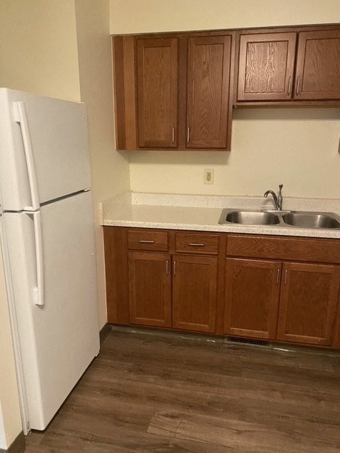 a kitchen with a white refrigerator and a sink