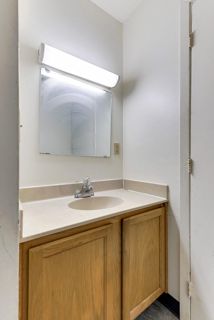 an empty bathroom with a sink and a mirror