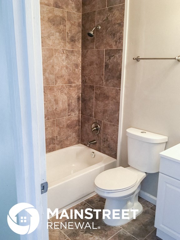 a small bathroom with a toilet and a bath tub