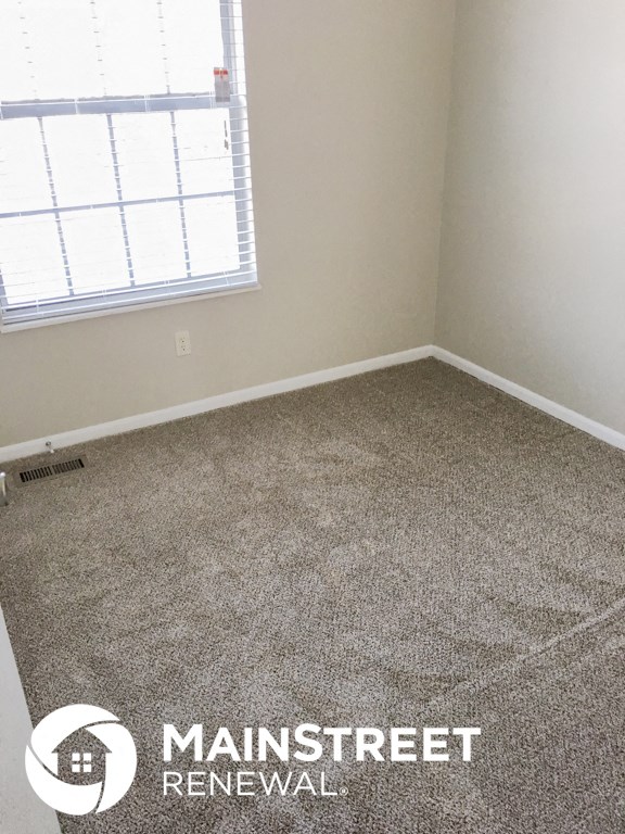 an empty room with a carpeted floor and a window