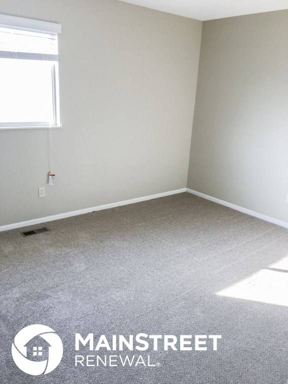 an empty room with a carpeted floor and a window