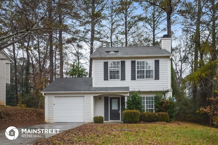 a white house with black shutters and a yard