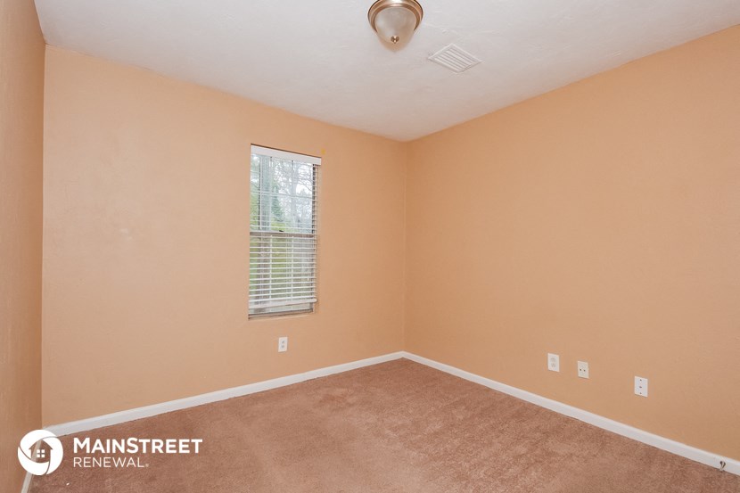 the upstairs bedroom with carpet and a window