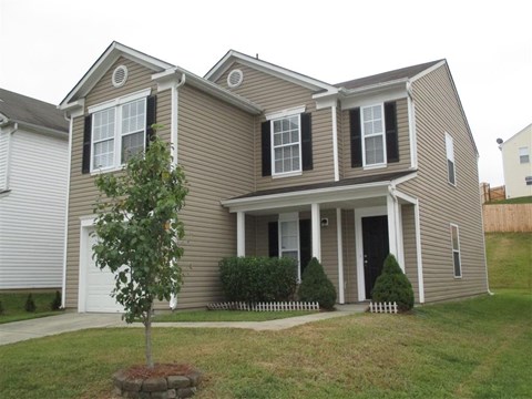 a house with a tree in the front yard