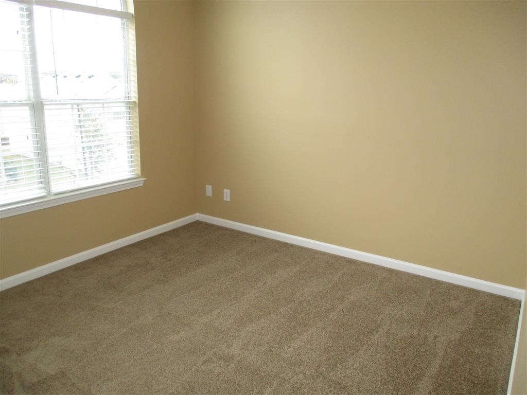 an empty room with carpet and a window