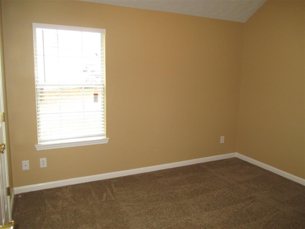 a room with a window and a carpeted floor