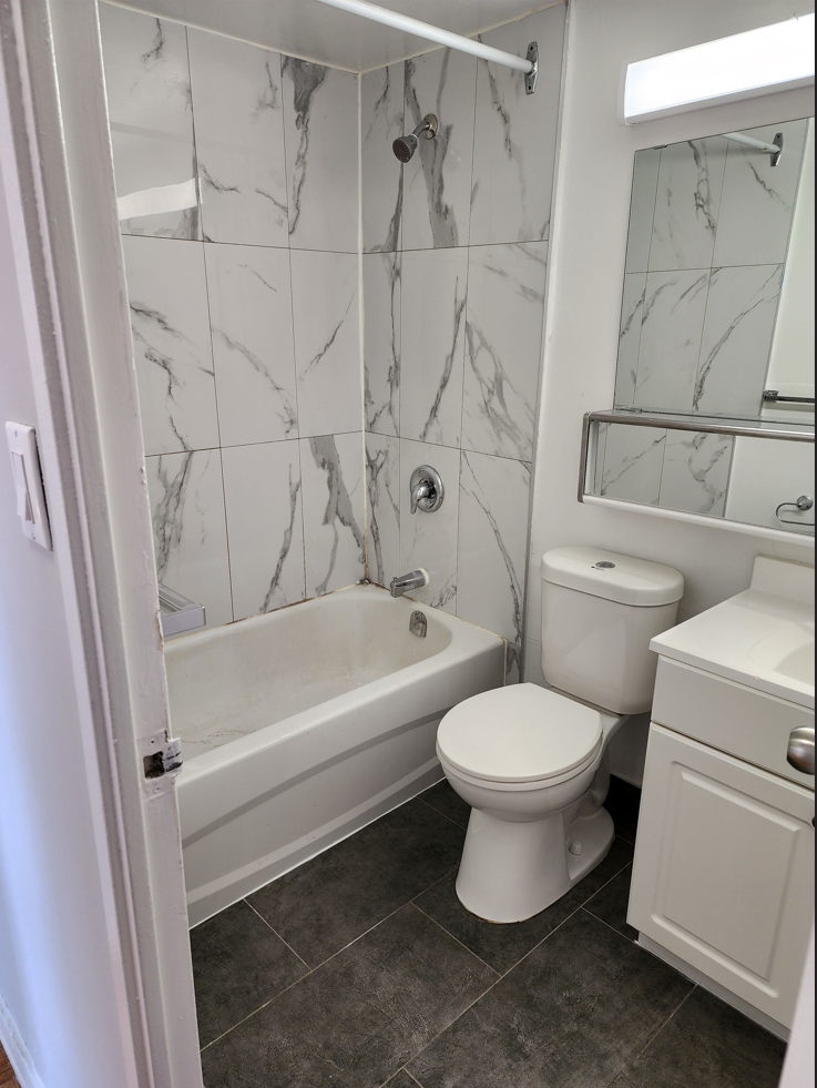 a small bathroom with a tub toilet and sink