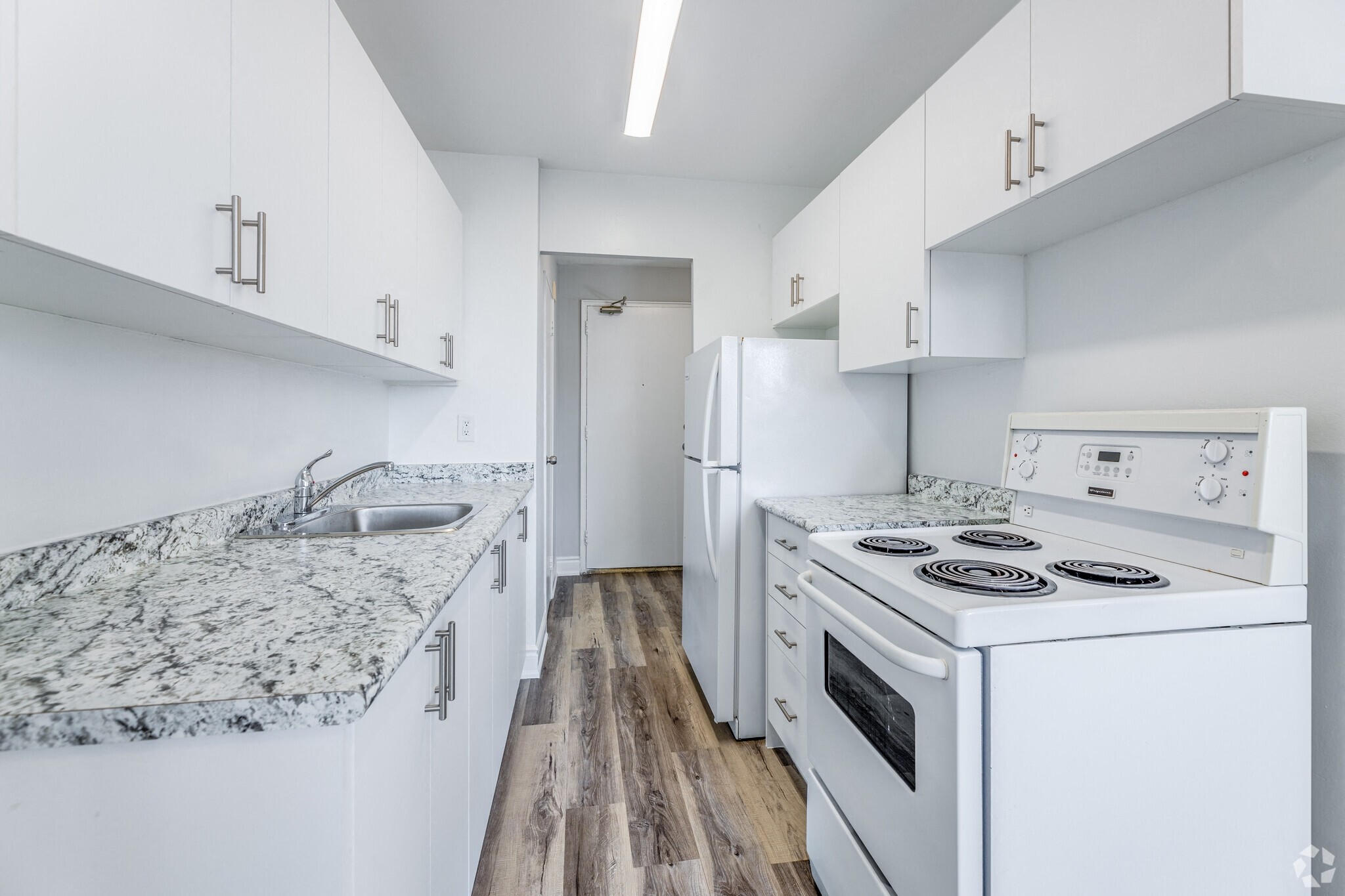 A kitchen with white cabinets and a granite countertop.