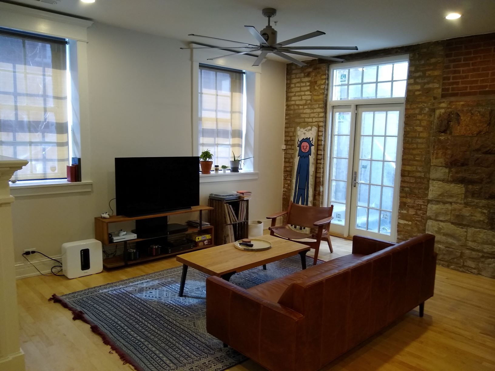 a living room with a leather couch and a television