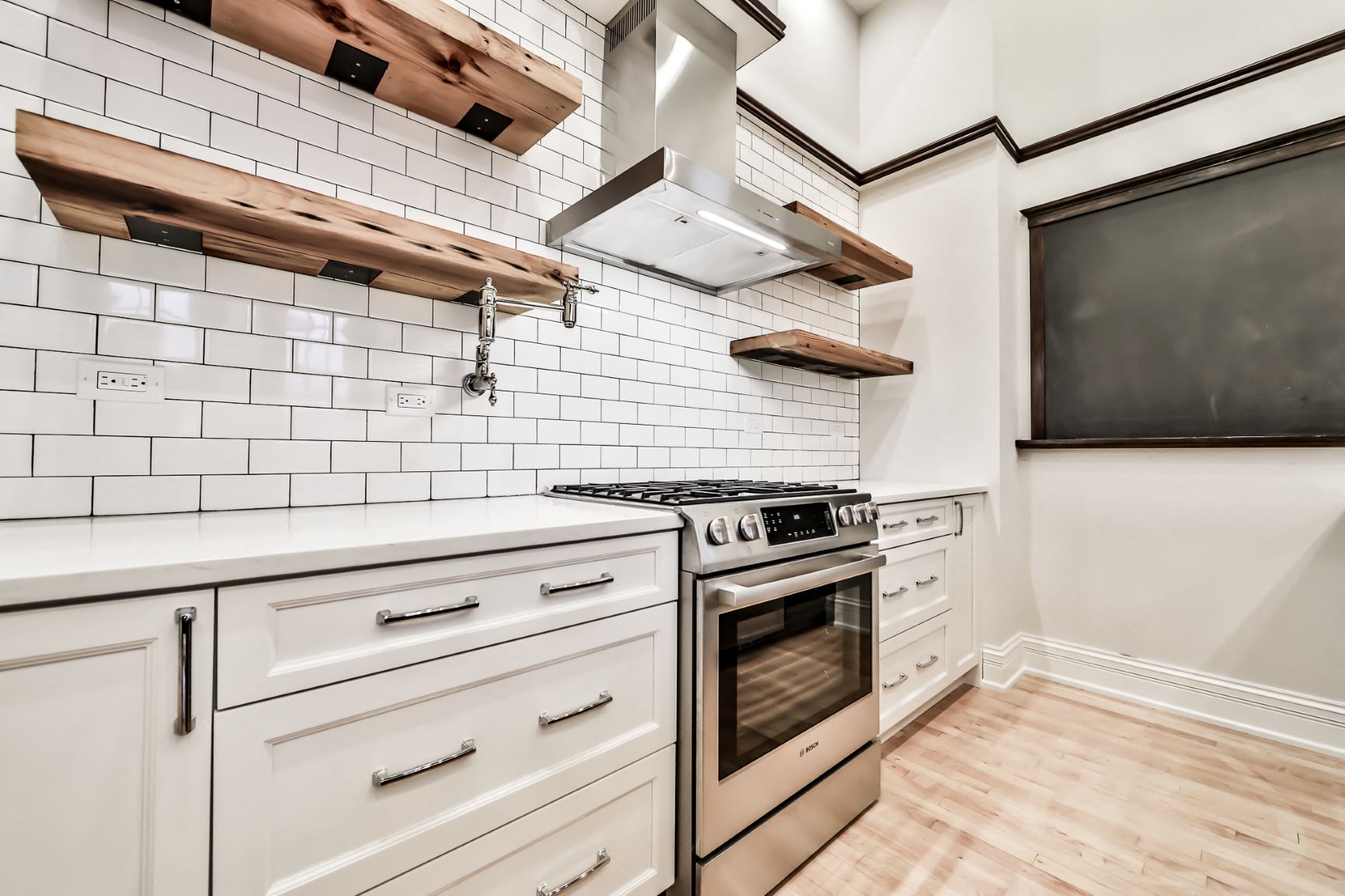 a kitchen with white cabinets and stainless steel appliances